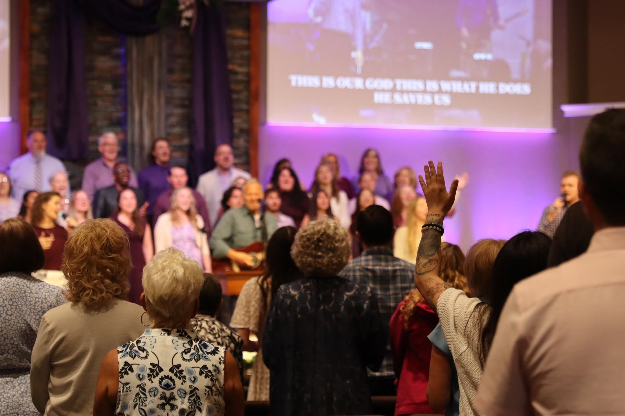 Congregation standing with some hands raised during a worship service
